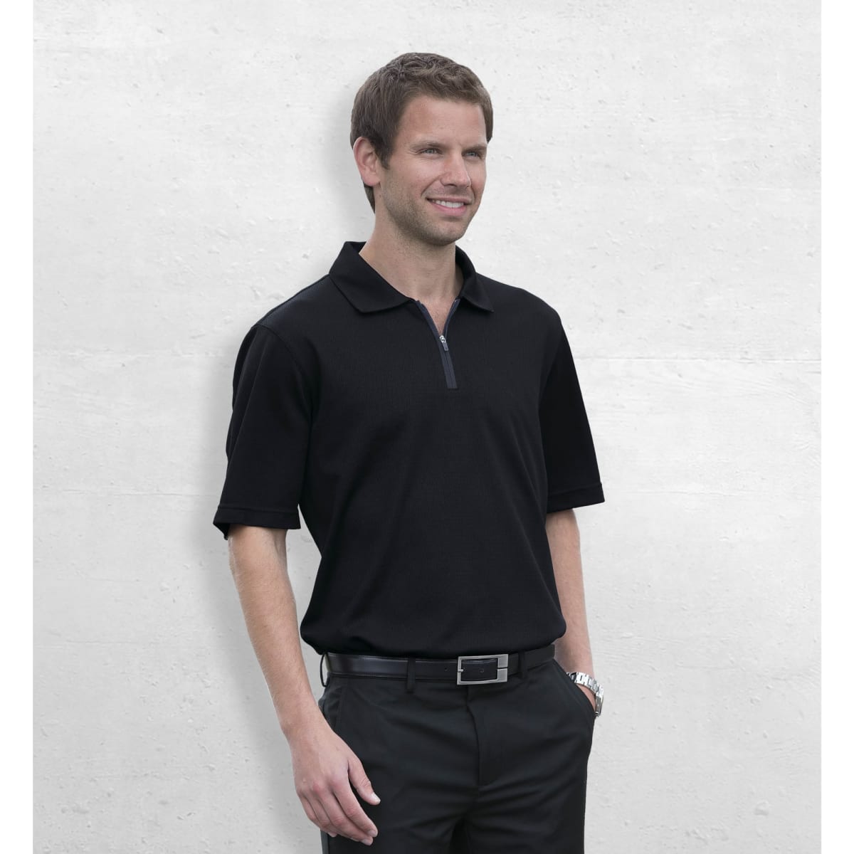 A black polo shirt with a zip collar, featuring short sleeves and a logo on the chest, worn by a smiling man.