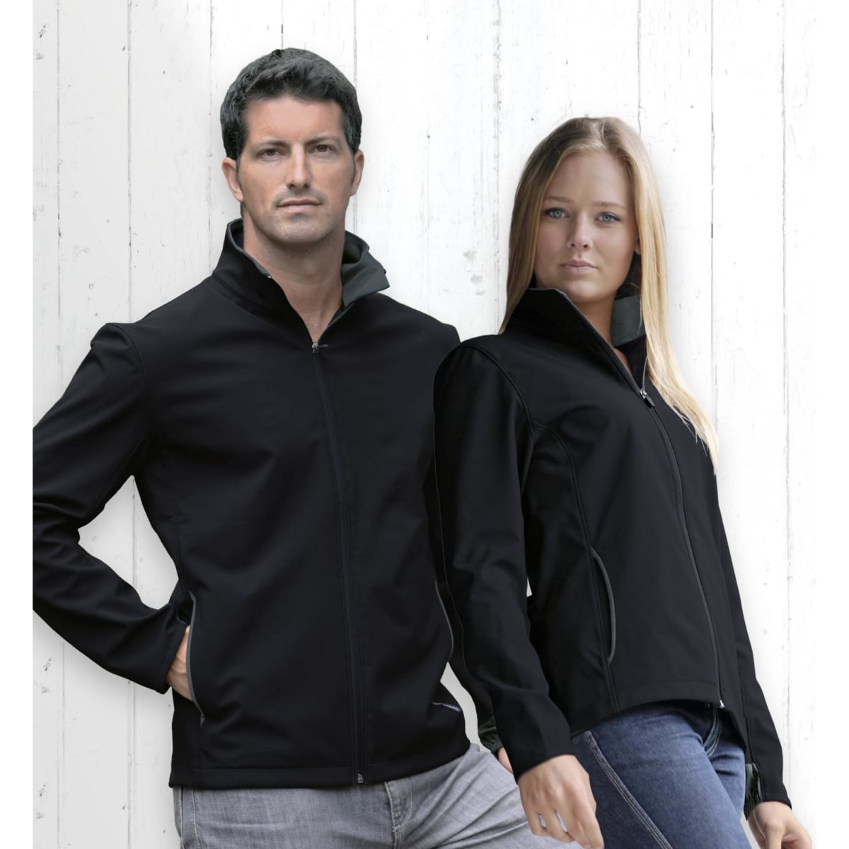 A black soft shell jacket for women, featuring a zip front and standing collar, displayed with a male model in a similar jacket.