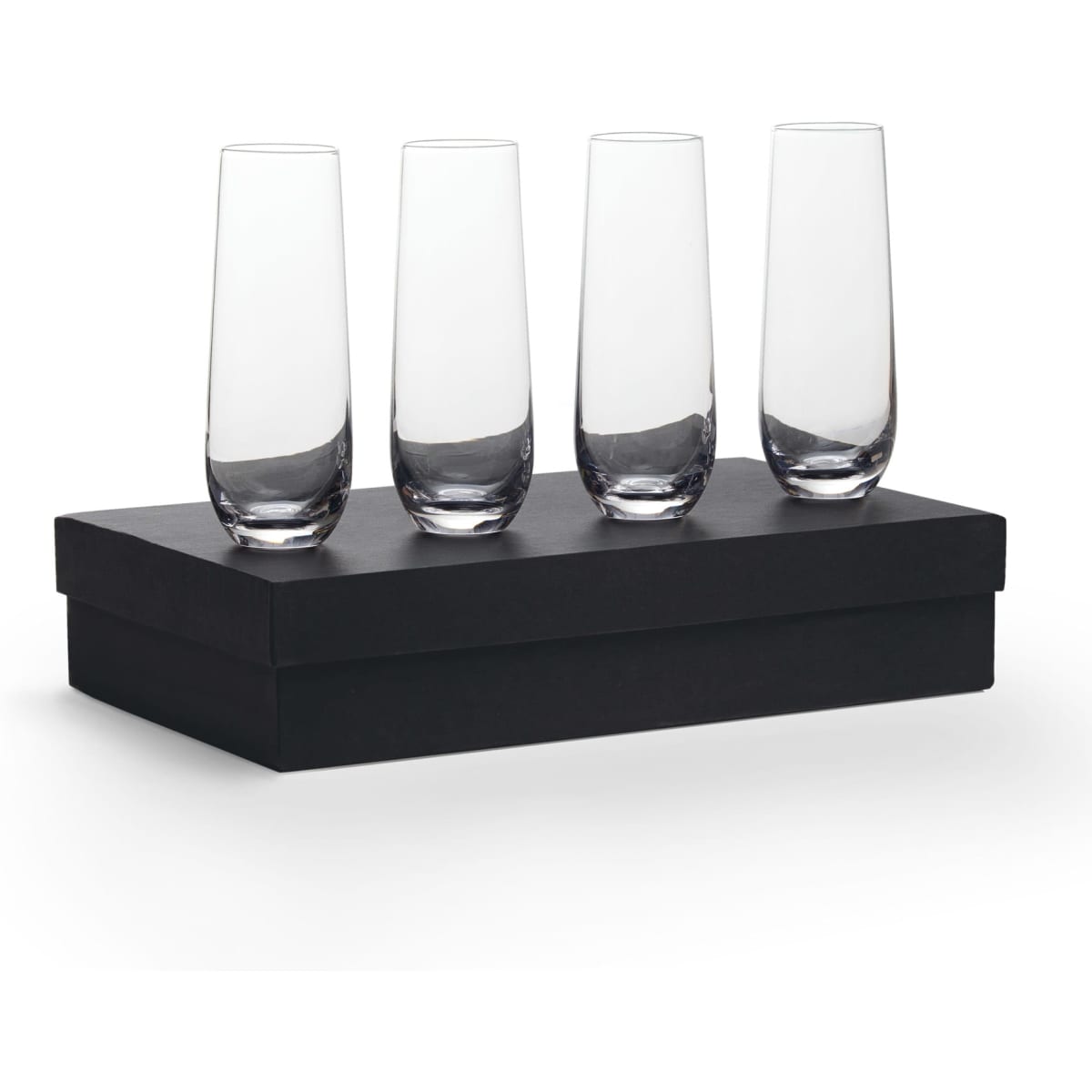 Four clear glass stemless champagne flutes arranged on a black gift box.