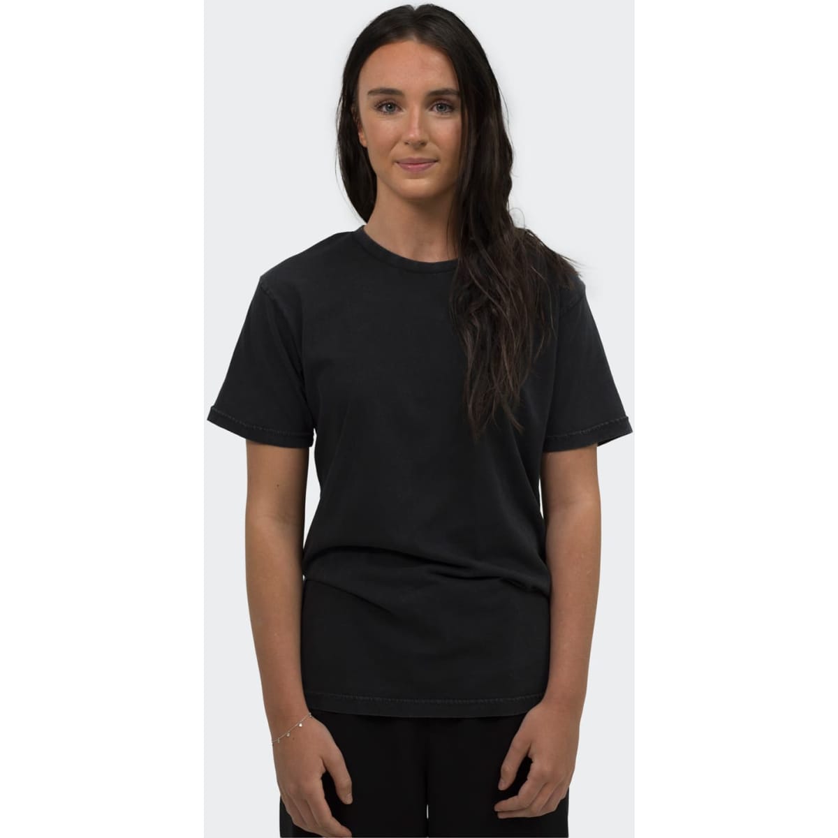 A black unisex T-shirt displayed on a model, featuring a simple design and a relaxed fit.