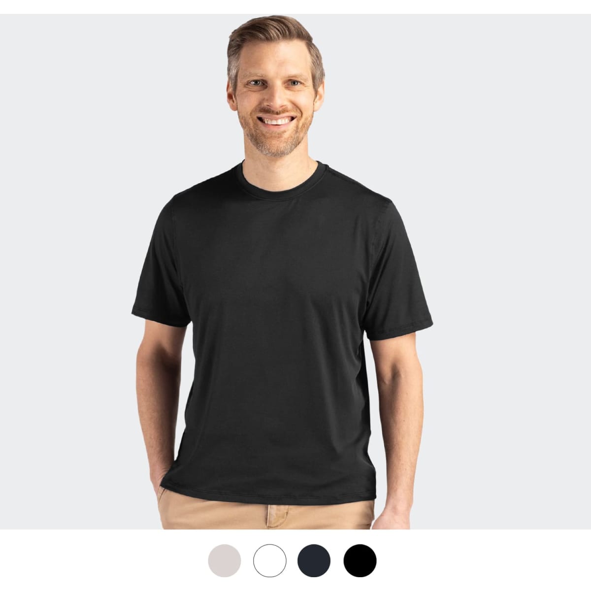 A man is wearing a black Cutter & Buck Coastline Epic Comfort Tee, featuring a logo on the shirt.