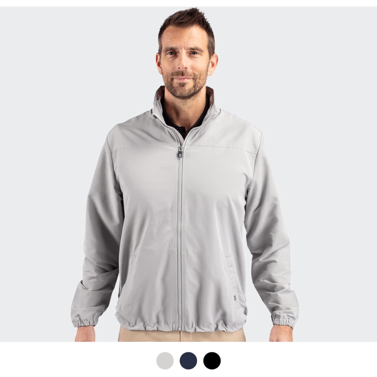 A man wearing a light grey full zip jacket with a collar, featuring an elasticated hem and cuffs.