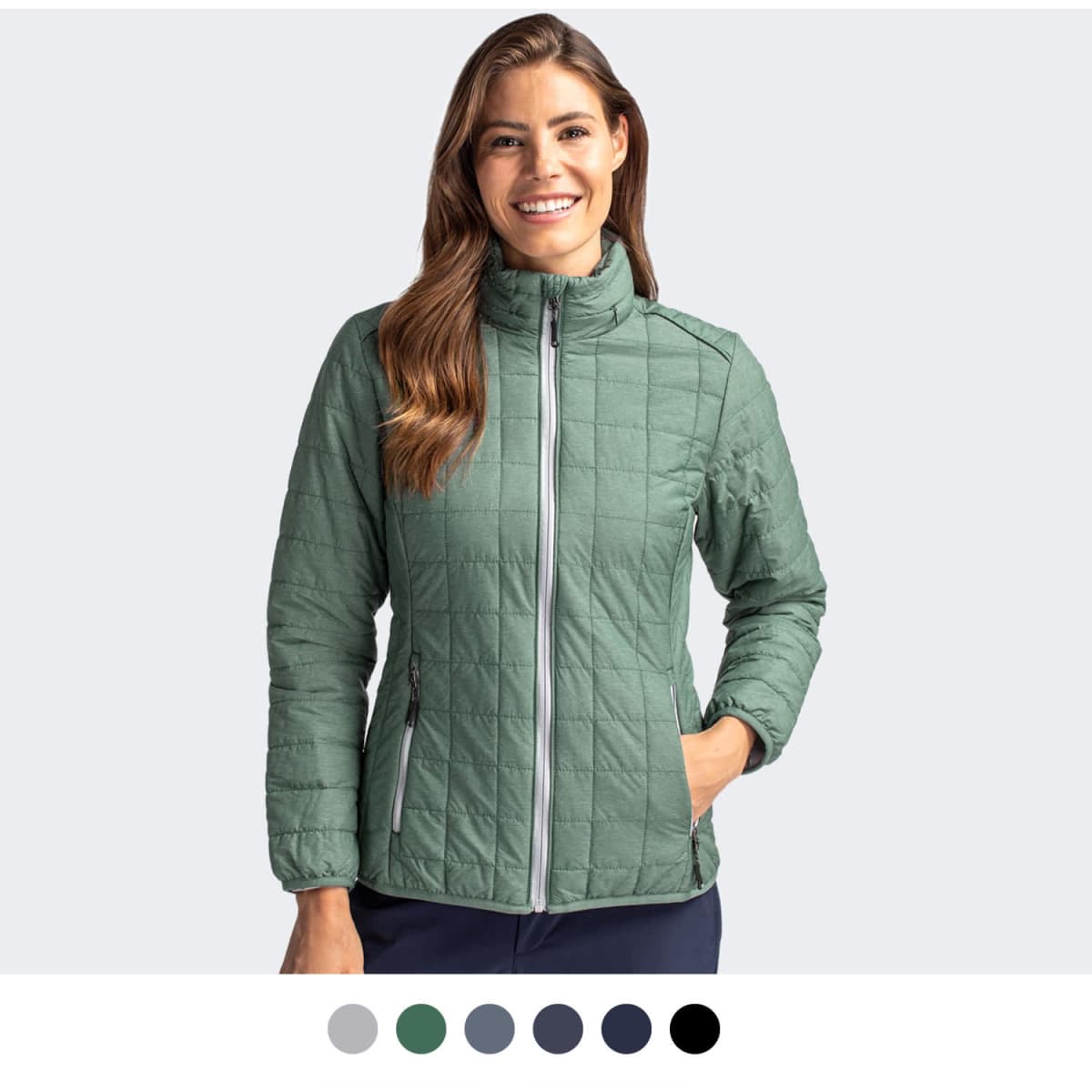 A women's jacket in green with a quilted design, featuring a zip front and one hand in the pocket.