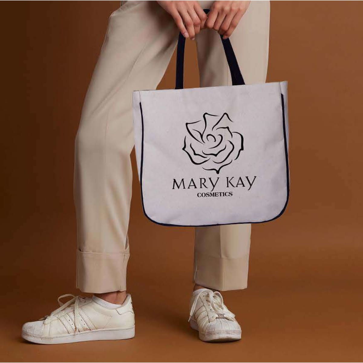 A two-tone calico shopper bag in white with a dark navy trim, featuring a logo on the front.