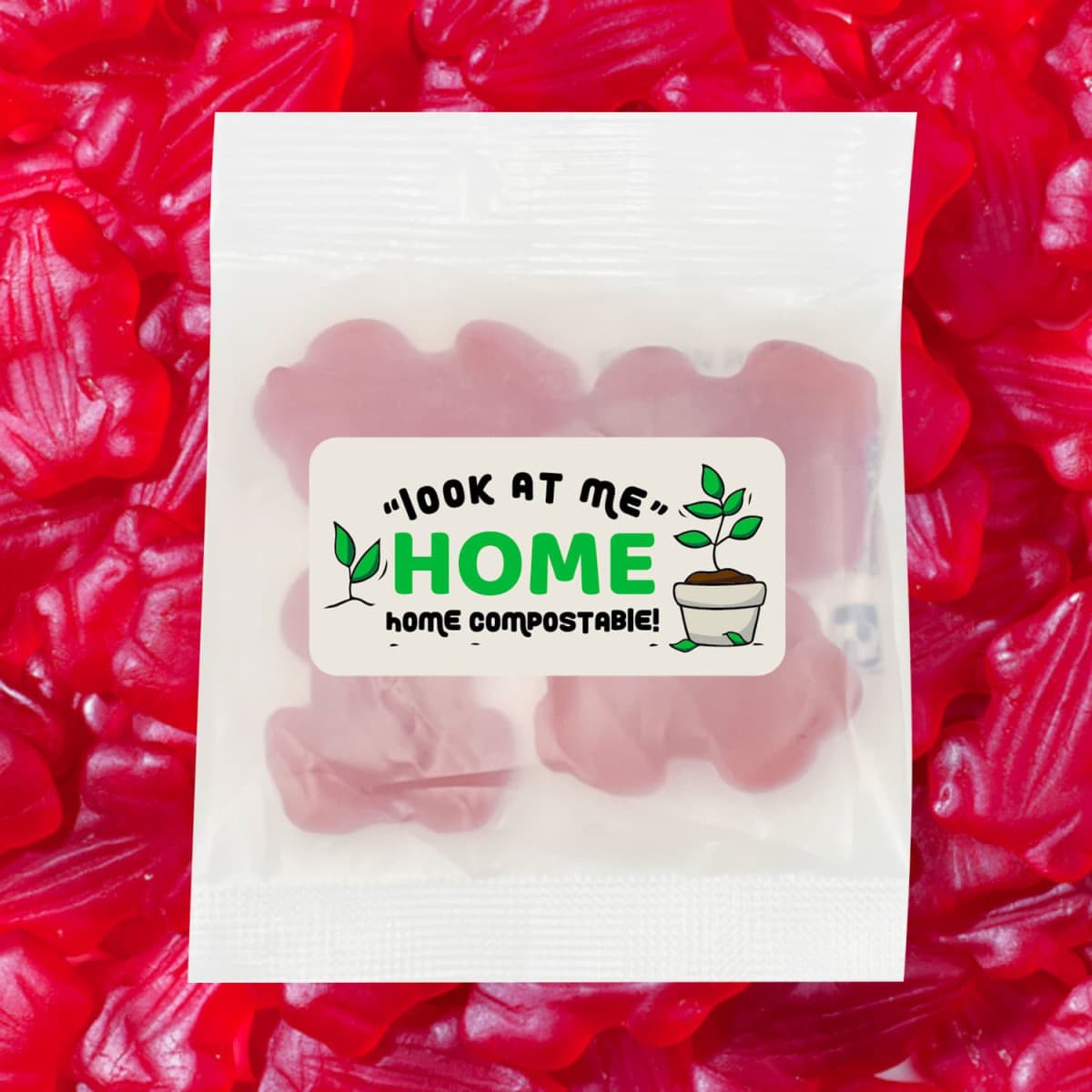 A packet of red gummi frogs with a logo, placed on a bed of similar red candies.