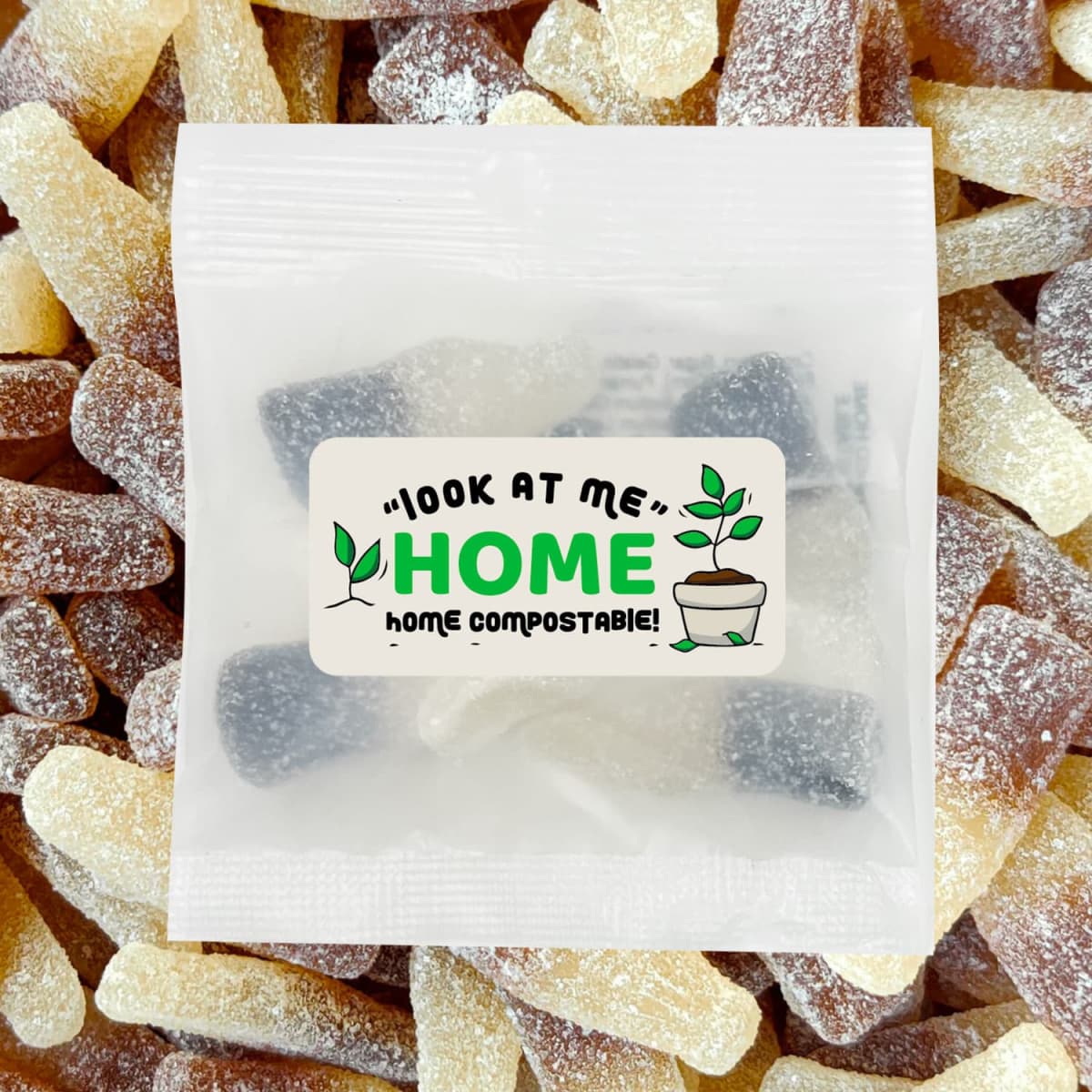 A clear bag containing ECO Sour Cola Bottles, featuring brown and yellow gummy sweets, with a compostable label.