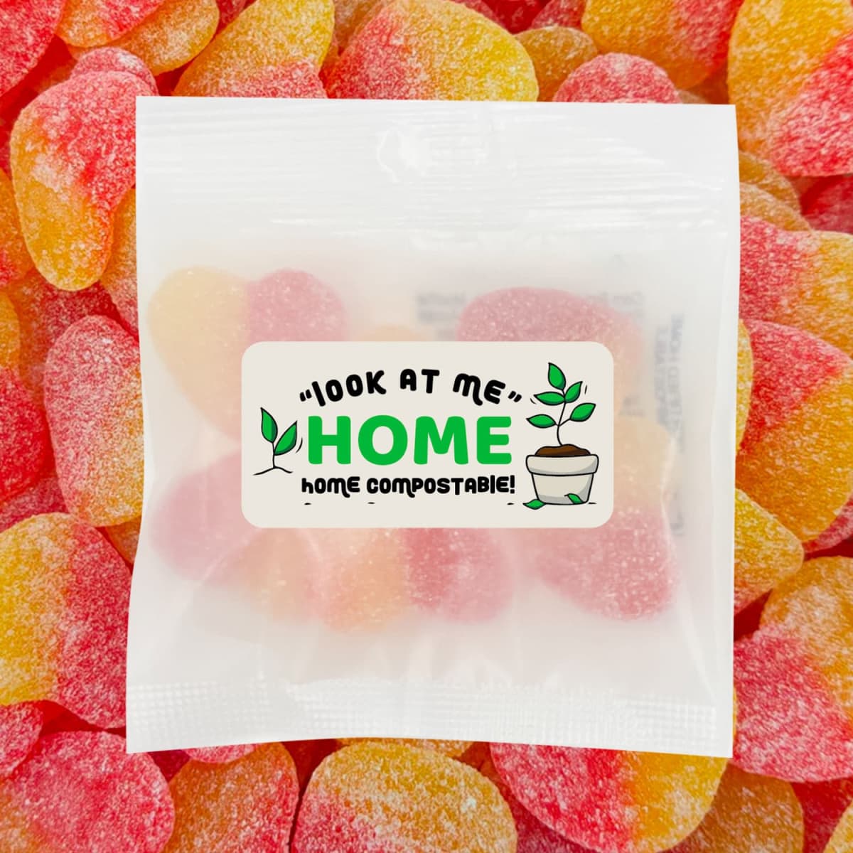 A packet of ECO Sour Peach Hearts with red and yellow gummy lollies, featuring a home compostable label.