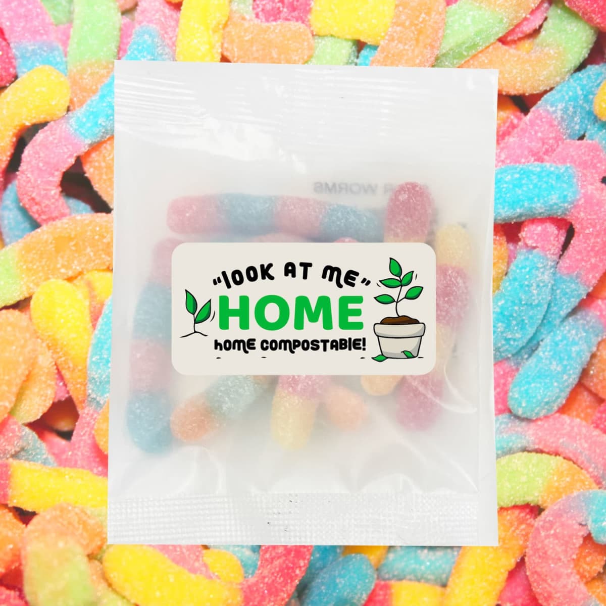 Colourful sour gummy worms in a clear bag, surrounded by more gummy worms in vibrant hues. Includes a logo.