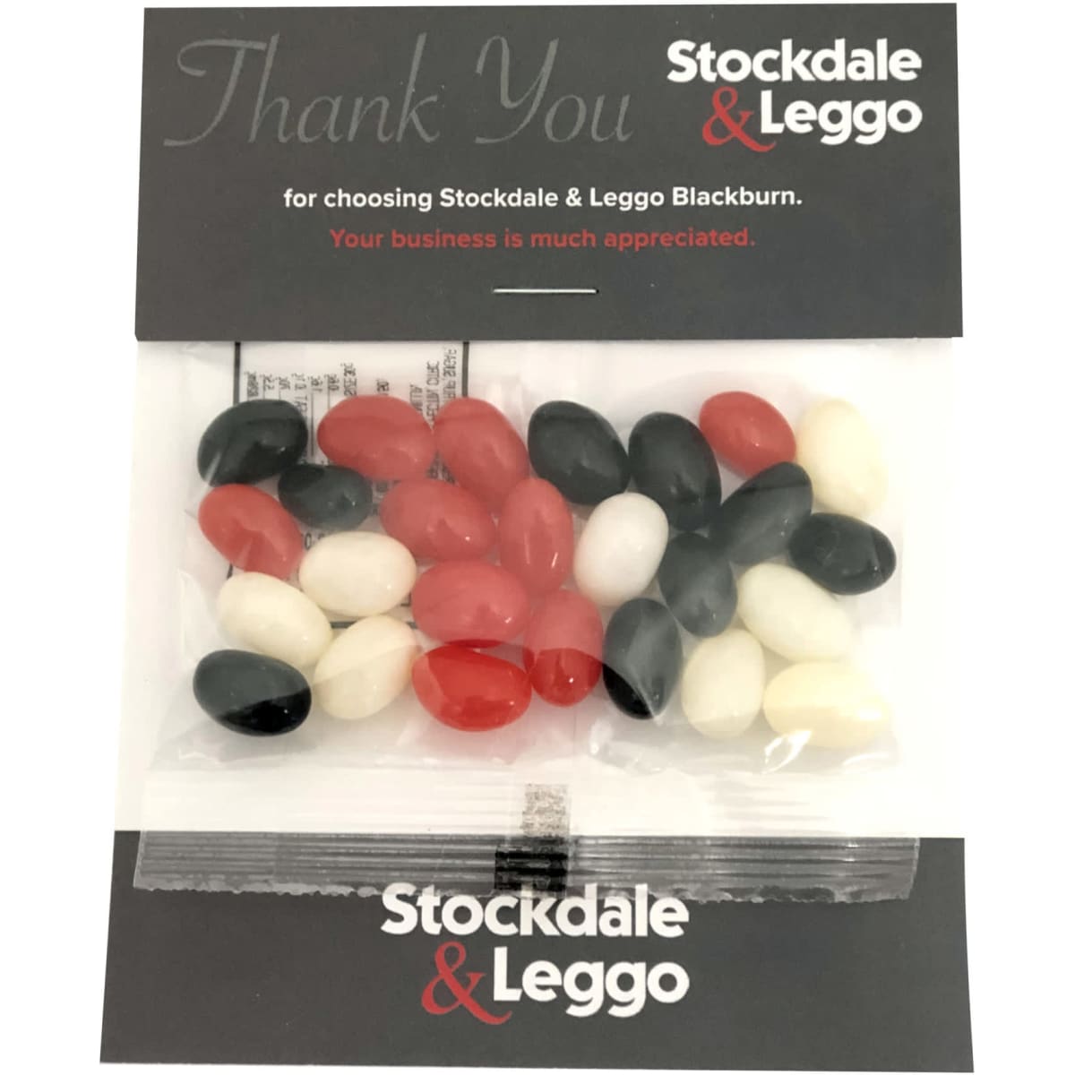 A plastic package containing an assortment of red, black, white, and pink jelly beans.