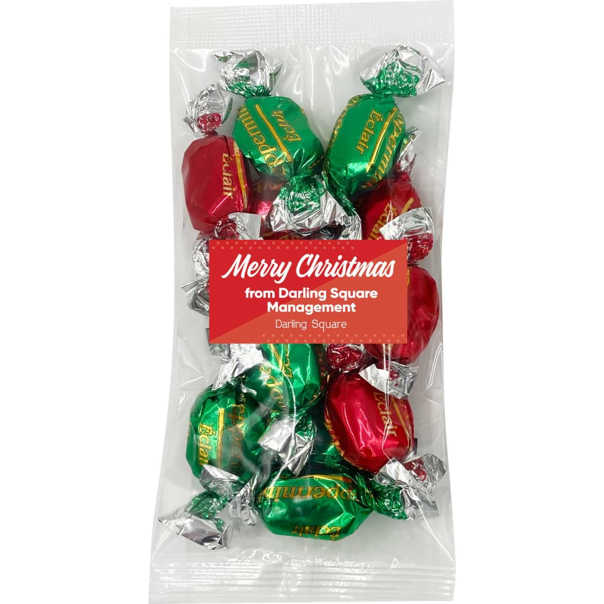A pack of Christmas toffees with red and green wrappers, featuring silver foil. The pack has a logo on it.