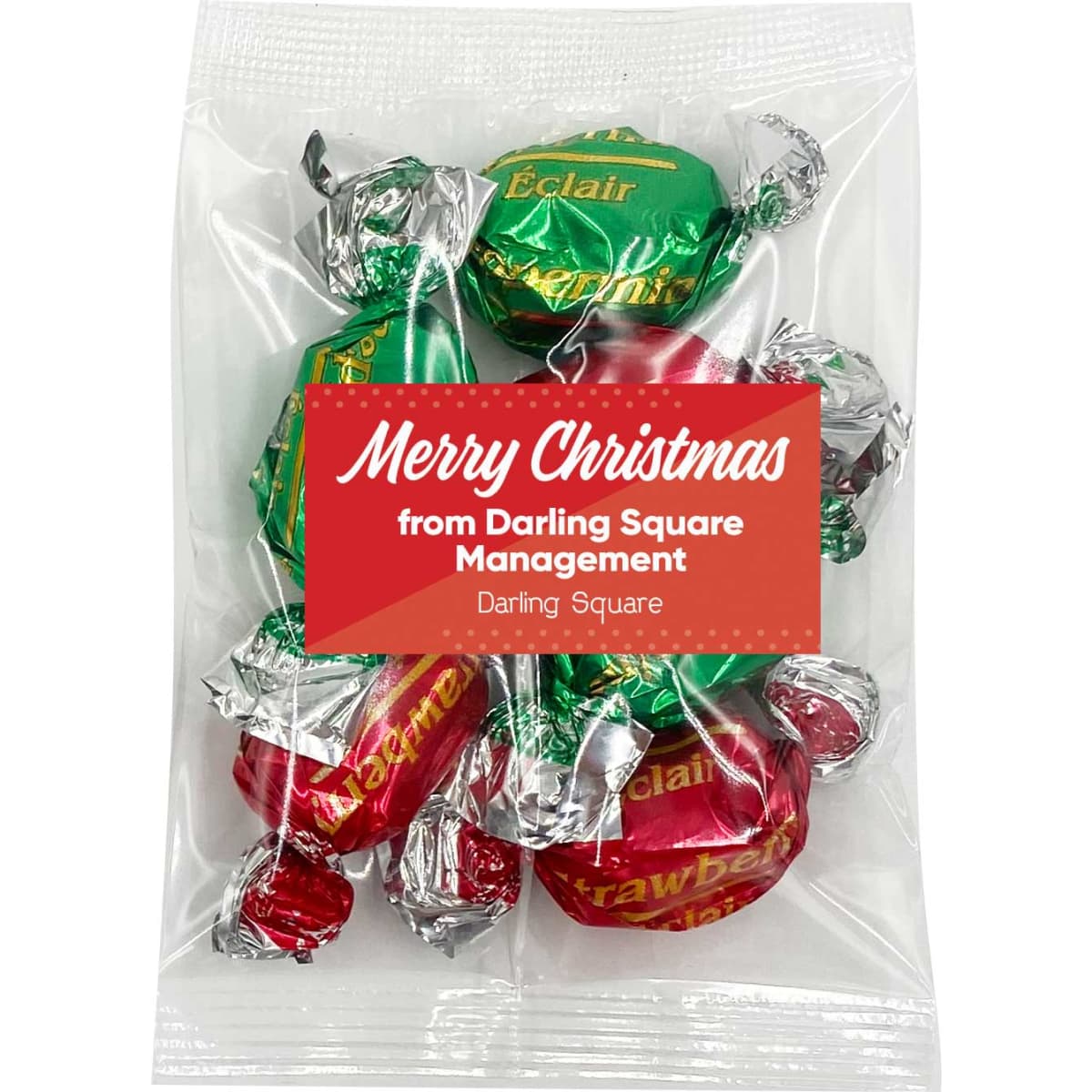 A clear bag of Christmas toffees featuring green and red wrapped sweets. The bag has a logo and festive message.