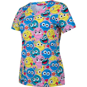 A printed scrub top featuring a vibrant design with various smiling cartoon faces in blue, pink, and yellow.