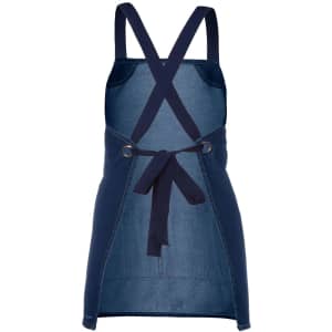 A navy denim bib apron with a cross-back design and ties at the waist, featuring a branding logo.