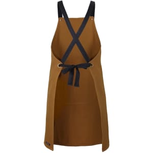 A brown cross-back canvas apron with black straps and a tied waist, featuring a logo.