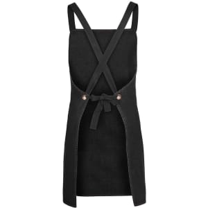 A black denim apron with cross back straps and a tie waist, featuring a logo.