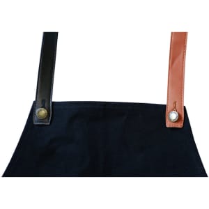 A black apron with changeable PU cross-back straps in black and brown, featuring metal buttons.