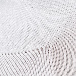 A close-up of a textured white fabric, featuring a knit pattern with visible stitch details.