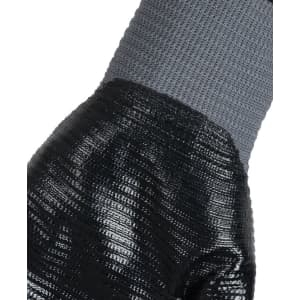 A close-up of a grey and black nitrile gripper glove, featuring textured grip and knitted wrist.