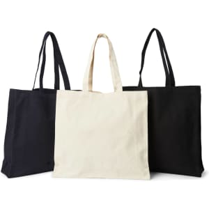 Three tote bags in black and cream, featuring long handles and a simple design, one bag in the front is cream.