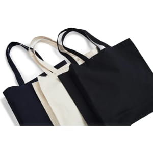 A set of heavy tote bags in black, cream, and beige, featuring sturdy straps and a simple design.