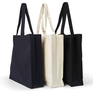 A heavy tote bag collection featuring navy, cream, and black fabric, with long handle straps and a simple design.