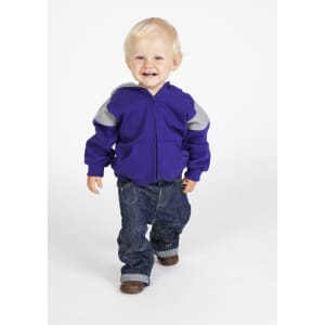 A smiling child in a purple hoodie with grey contrast panels and denim jeans, walking towards the camera.