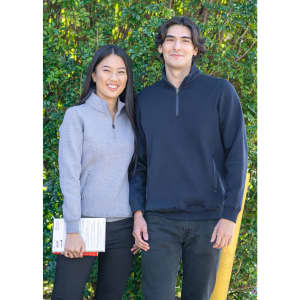 A woman in a grey half zip fleece and a man in a navy half zip fleece, both standing outdoors.