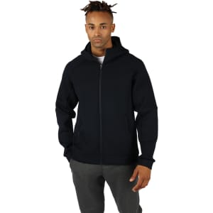 A black zip-up men's hoodie with a hood and side pockets, worn by a model.