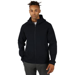 A black men's hoodie with a zip front, featuring a hood and a simple design, worn by a model.