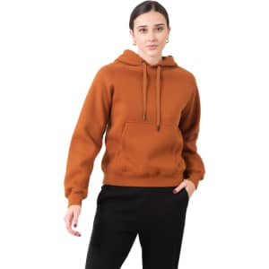 A model wearing a brown cotton hoodie with a kangaroo pocket and drawstring hood, alongside black pants.