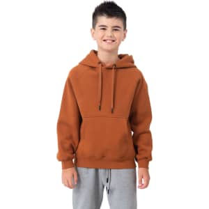 A junior cotton hoodie in a warm brown colour featuring a kangaroo pocket and a hood. The model wears grey pants.