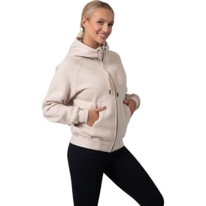 A women's cotton hoodie in light beige with a kangaroo pocket and a zipper, featuring a logo on the hood.