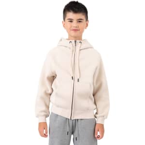 A cream cotton hoodie featuring a kangaroo pocket and zip closure, modelled by a boy.