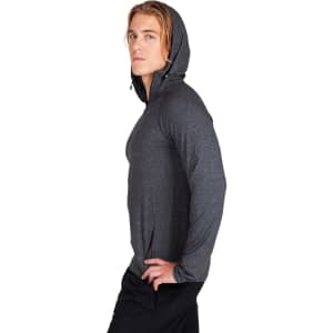 A male model wearing a grey half-hood top, featuring a fitted style and a hood. The top has a logo.