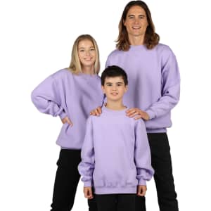 A light lavender crew neck jumper displayed on a group of three people, including adults and a child. The garments have a logo.
