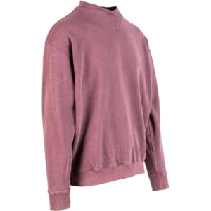 A unisex stone wash sweatshirt in a muted mauve colour, featuring a simple design and a logo.