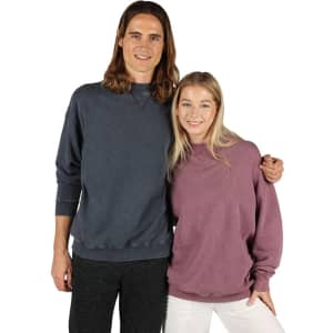 A man in a dark blue sweatshirt and a woman in a purple sweatshirt pose together, both wearing casual attire.