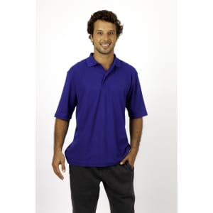 A man wearing a blue regular pique knit polo shirt, featuring a logo, and dark grey trousers.