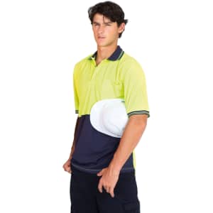 A high visibility polo shirt in bright yellow and navy, featuring a logo and held with a white hard hat.