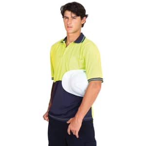 A high visibility polo shirt in bright yellow and navy blue, featuring a branded logo, held by a model wearing work pants.