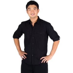 A black men's military long sleeve shirt with button-up front and two chest pockets. The model poses with hands on hips.