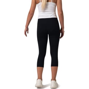 High-rise black 3/4 leggings with a fitted design, worn by a model from the back, featuring a logo.