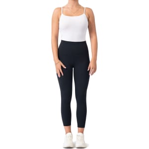 High-rise full-length leggings in black, paired with a white tank top and white sneakers.