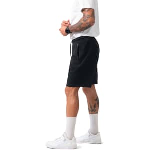 Men's black cotton sandwich shorts with an elastic waistband and pockets, modelled by a person wearing a white T-shirt and sneakers.