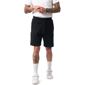 Men's cotton dress shorts in black, featuring an elastic waistband and zippered pockets, with a model standing.