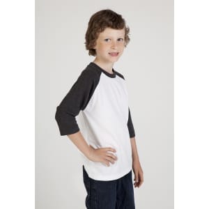 A child models a white and dark grey 3/4 raglan sleeve t-shirt with a logo on the front.