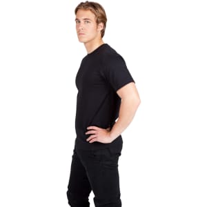 A black modern fit T-shirt worn by a man, with a logo on the shirt. The model stands in profile against a white background.