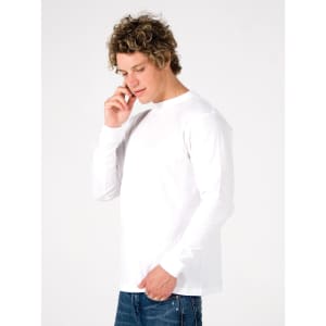 A white long sleeve T-shirt displayed on a model who is holding a phone, with a plain background.