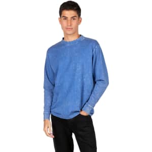 A blue stone wash long sleeve T-shirt worn by a model, featuring a casual fit and a logo on the sleeve.