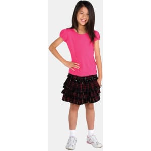 A girl is wearing a pink short puff sleeve T-shirt paired with a black plaid skirt and white shoes.